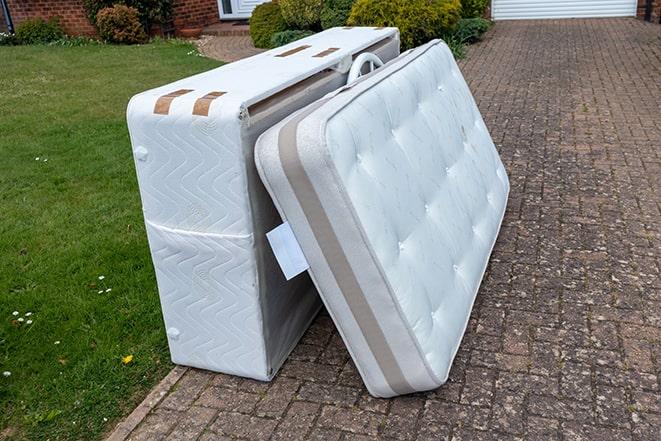 a mattress being hauled away from a curb